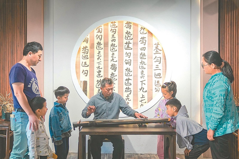 翟光宝（中）正在向游客展示古琴弹奏。.jpg
