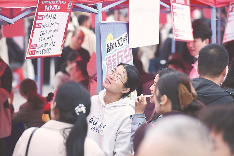 10月12日，在阜阳市2025年就业政策宣传月专项活动暨金秋招聘会现场，求职者在了解招聘信息。当天，该市近60家企业带来2000多个岗位，吸引众多求职者前来咨询、应聘。.jpg