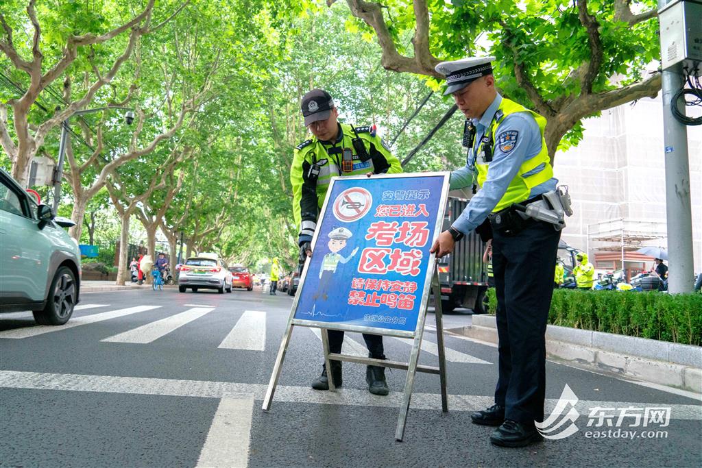图为徐汇公安分局民警在上海市南洋模范中学考点附近放置禁止鸣号标牌(蔡黄浩/摄)